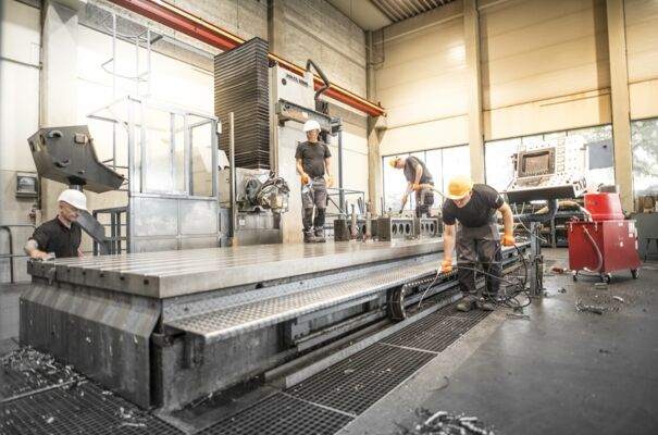 Vier Mitarbeiter bei der Reinigung einer industriellen Maschine