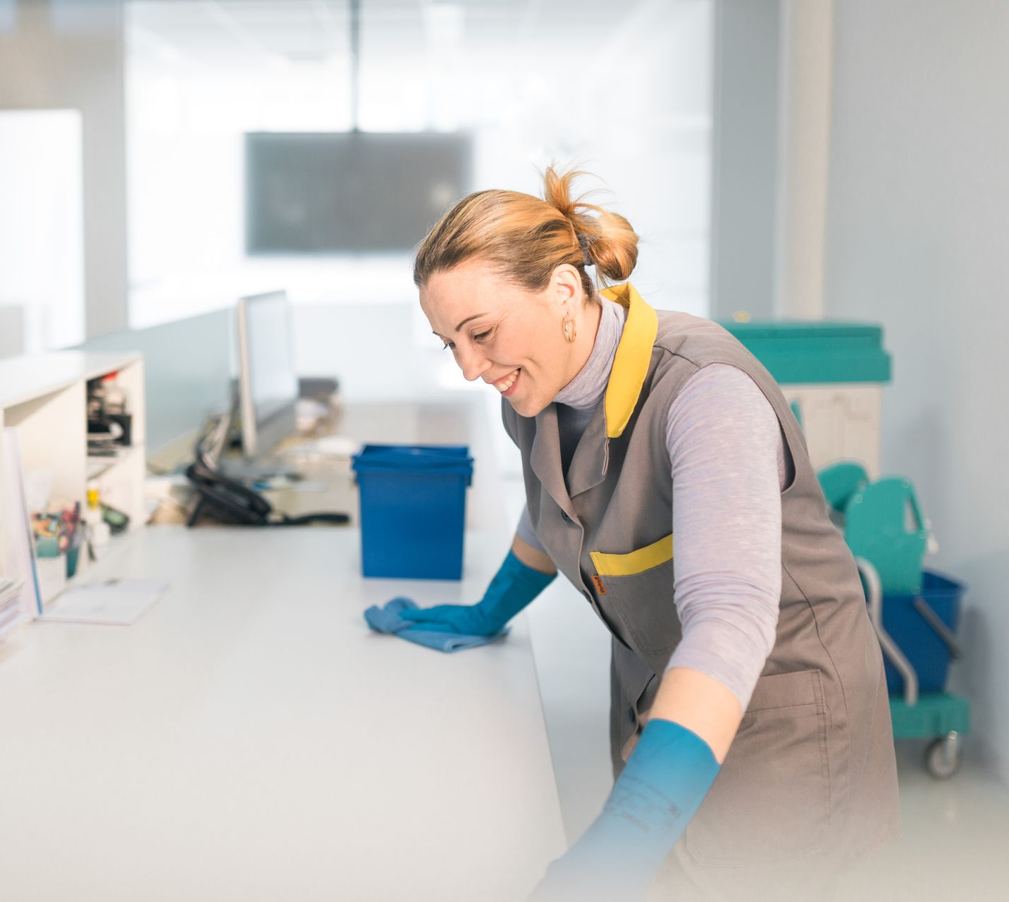 Facilityfachkraft beim Bürotisch putzen